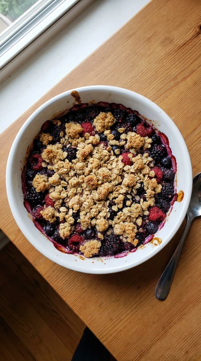 A baked berries crumble with a golden topping